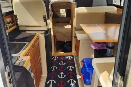 Slide: The Image of 2013 Cutwater C-26 interior with kitchen, seating, and nautical-themed decor. - 11