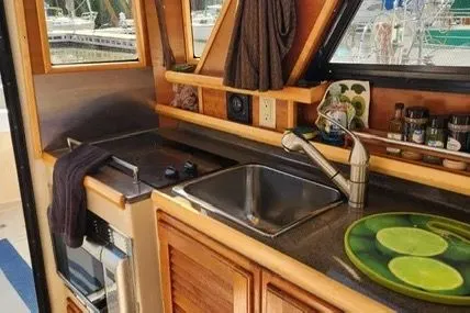 Slide: The Image of Compact kitchen in 2013 Cutwater C-26 boat with sink, stove, and wooden cabinetry. - 12