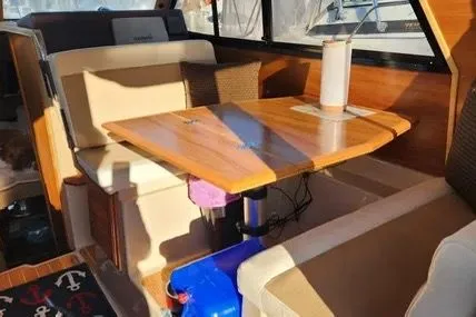 Slide: The Image of Interior of 2013 Cutwater C-26 boat with wooden table and beige seating. - 13