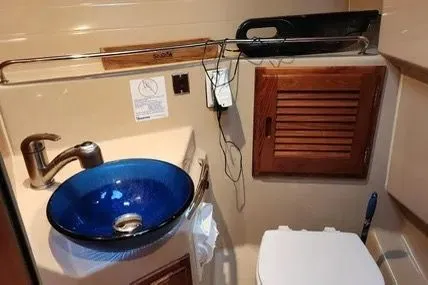 Slide: The Image of 2013 Cutwater C-26 bathroom with blue sink, wooden cabinet, and modern fixtures. - 15