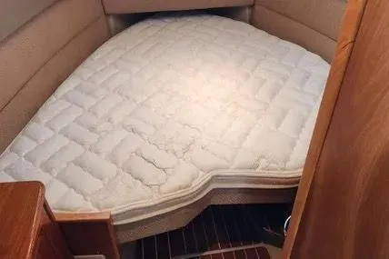 Slide: The Image of 2013 Cutwater C-26 boat interior with a cozy, quilted bed in the cabin. - 16