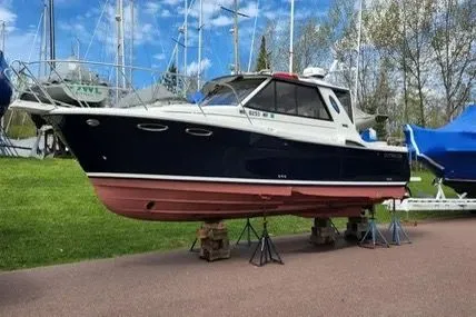 Slide: The Image of 2013 Cutwater C-26 boat on stands, displayed outdoors with sailboats in the background. - 5