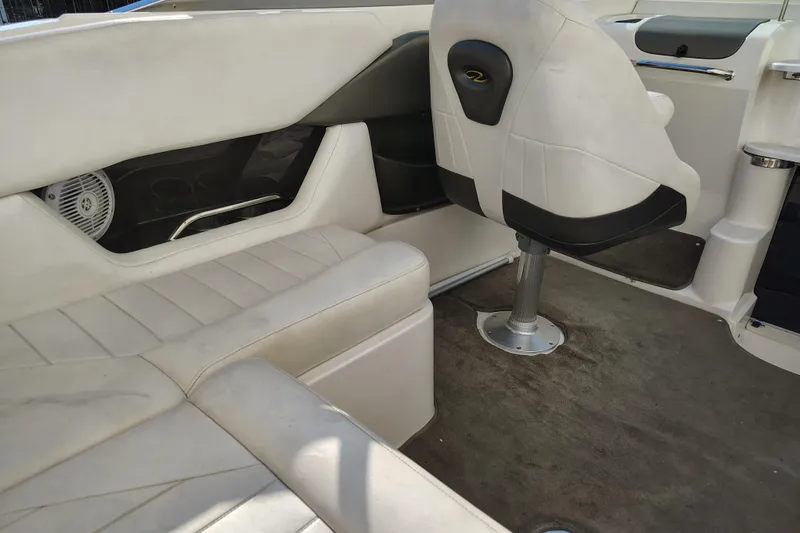 Slide: The Image of Interior of a 2006 Regal 2250 Cuddy boat with white seating and carpeted floor. - 11