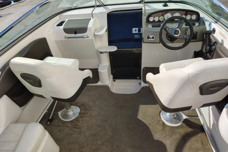 Slide: The Image of 2006 Regal 2250 Cuddy boat interior with steering wheel and seating arrangement. - 12