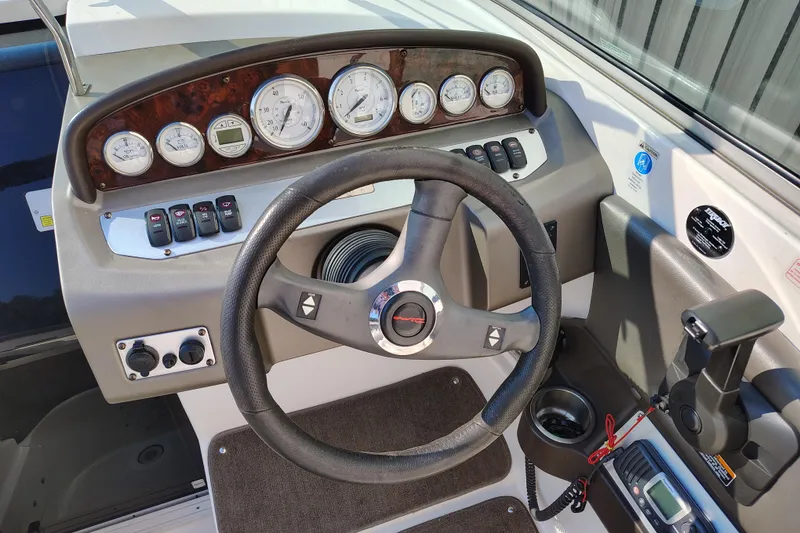 Slide: The Image of 2006 Regal 2250 Cuddy boat dashboard with steering wheel and instrument panel. - 13