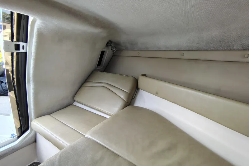 Slide: The Image of Interior of 2006 Regal 2250 Cuddy boat, featuring beige cushioned seating. - 19