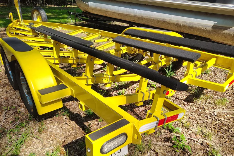 Slide: The Image of Yellow boat trailer for 2006 Regal 2250 Cuddy, parked on grassy ground. - 21