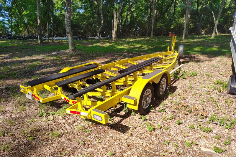 Slide: The Image of Yellow boat trailer for 2006 Regal 2250 Cuddy, parked in wooded area. - 26
