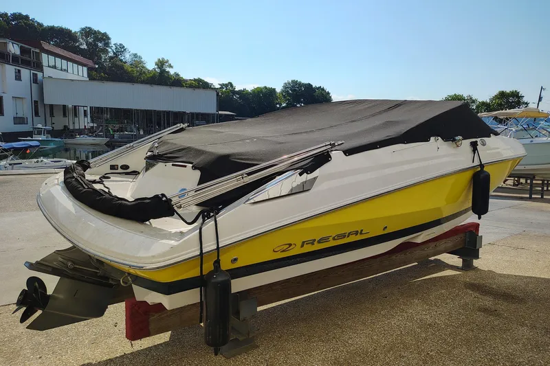 Slide: The Image of 2006 Regal 2250 Cuddy boat with cover, docked at marina under clear sky. - 5