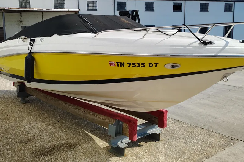 Slide: The Image of 2006 Regal 2250 Cuddy boat with yellow hull on a stand, docked outdoors. - 6