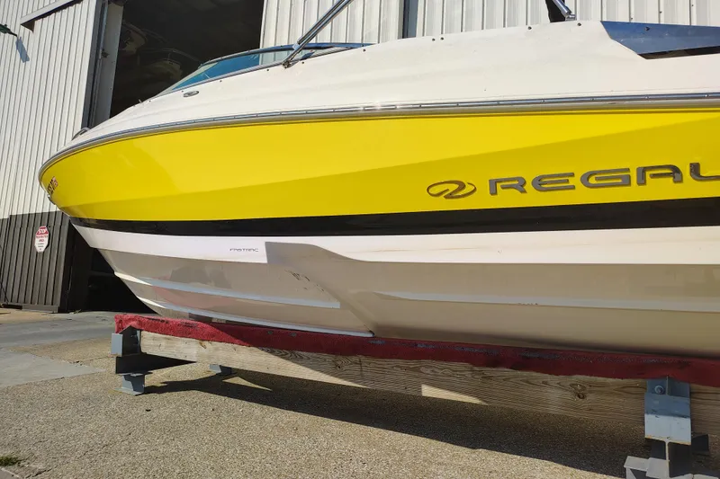 Slide: The Image of Yellow 2006 Regal 2250 Cuddy boat on trailer outside a building. - 9