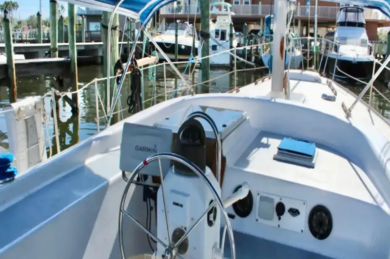 Slide: The Image of 1978 Morgan 415 sailboat cockpit with steering wheel, docked at marina. - 1