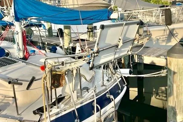 Slide: The Image of 1978 Morgan 415 sailboat docked, featuring blue sails and solar panels. - 11