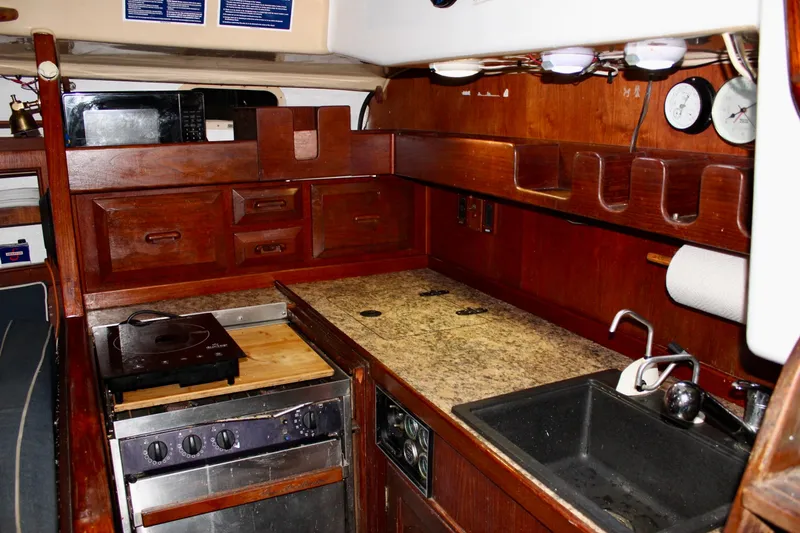 Slide: The Image of 1978 Morgan 415 yacht kitchen with wooden cabinetry, stove, and sink. - 12
