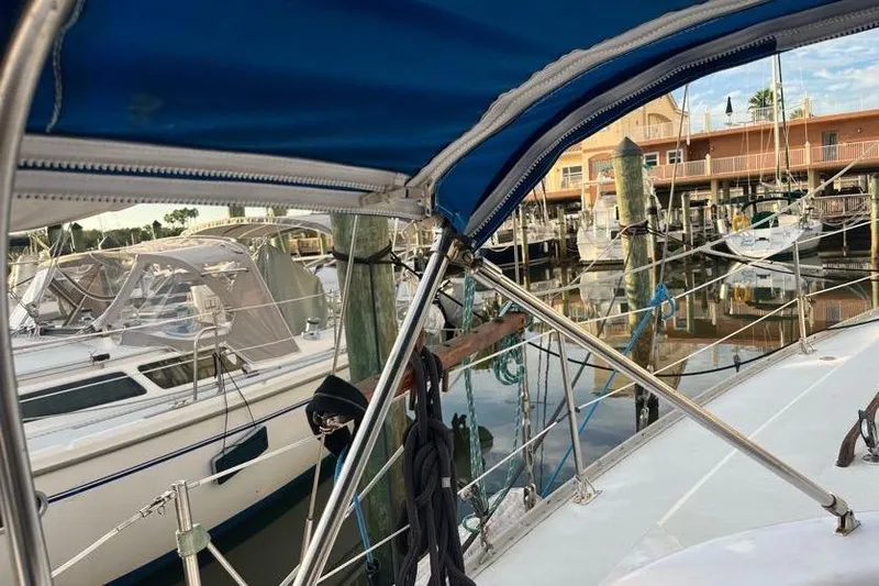 Slide: The Image of 1978 Morgan 415 sailboat docked in a marina, featuring a blue canopy and surrounding boats. - 13