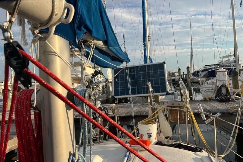 Slide: The Image of 1978 Morgan 415 sailboat docked, featuring solar panel and vibrant rigging. - 15