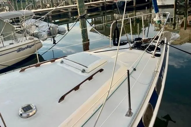 Slide: The Image of 1978 Morgan 415 sailboat docked in a marina, reflecting on calm water. - 2