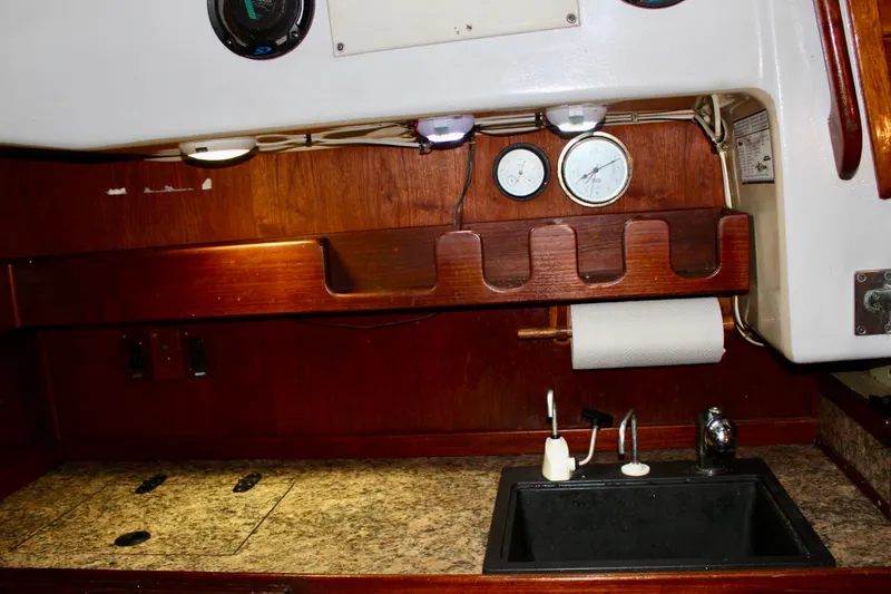 Slide: The Image of 1978 Morgan 415 yacht interior with wooden cabinetry, gauges, and a compact kitchen sink area. - 21