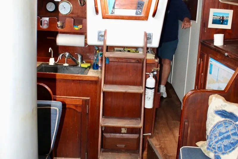 Slide: The Image of Interior of a 1978 Morgan 415 sailboat with wooden cabinetry and nautical decor. - 22