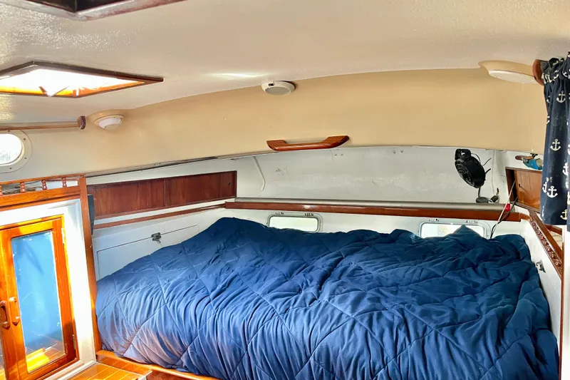 Slide: The Image of Cozy cabin interior of a 1978 Morgan 415 sailboat with a blue bedspread. - 26