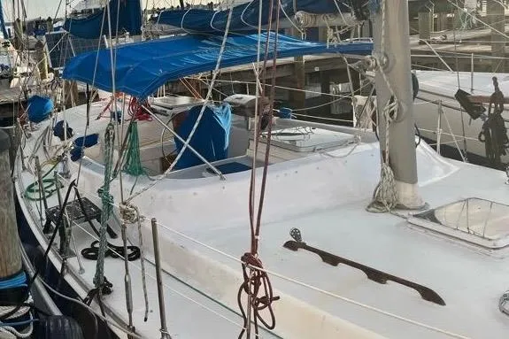 Slide: The Image of 1978 Morgan 415 sailboat docked, featuring blue covers and rigging. - 3
