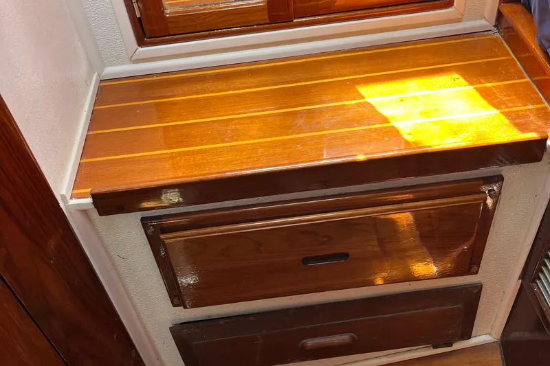Slide: The Image of Wooden interior of a 1978 Morgan 415 boat, featuring polished drawers and a sunlit surface. - 31