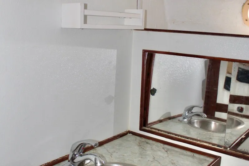 Slide: The Image of 1978 Morgan 415 yacht bathroom with sink, mirror, and white walls. - 35