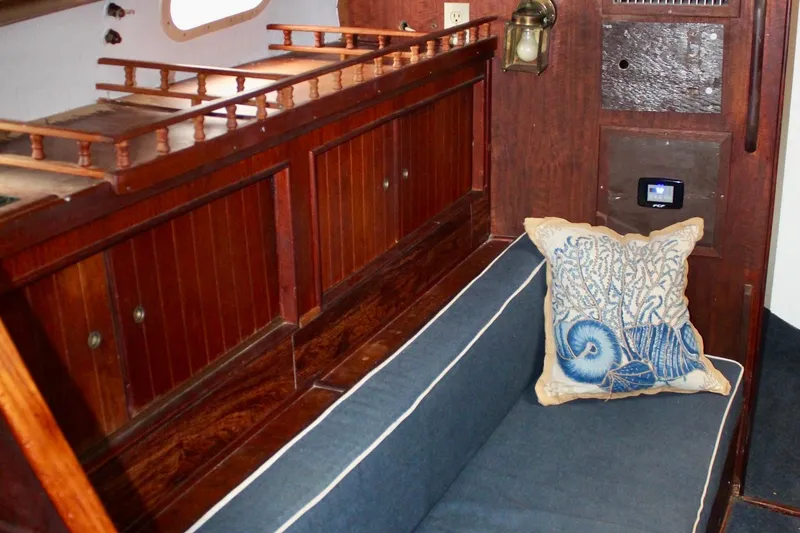 Slide: The Image of Interior of a 1978 Morgan 415 sailboat with wooden cabinetry and nautical-themed cushion. - 38