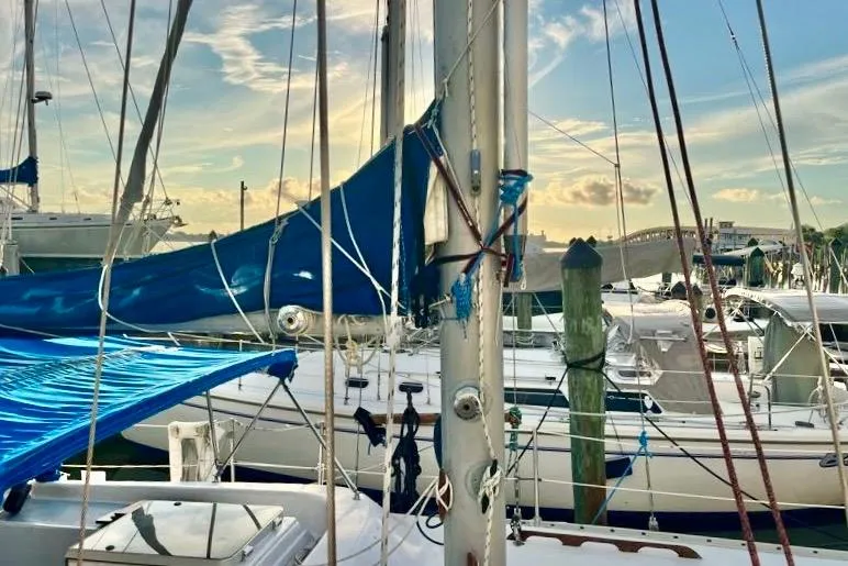 Slide: The Image of Sailboats docked at marina, featuring a 1978 Morgan 415 under a vibrant sky. - 4