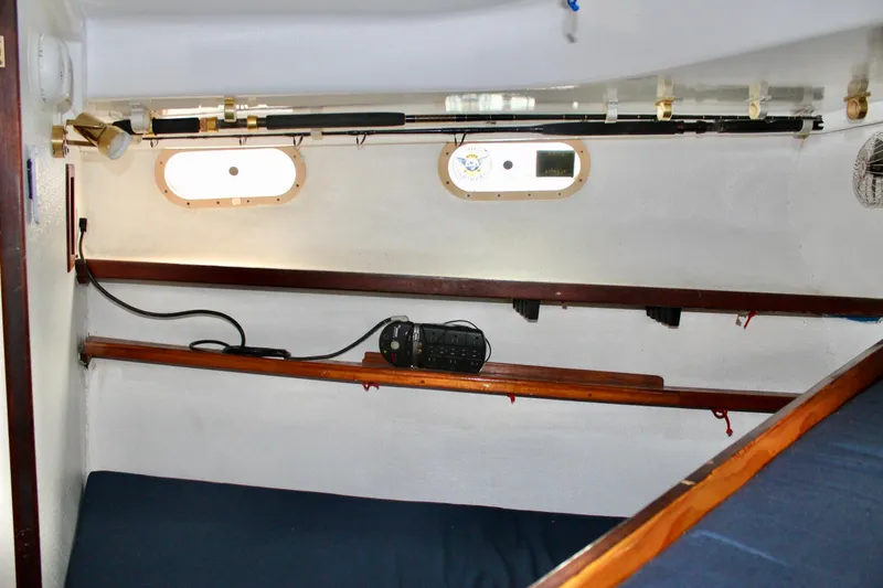 Slide: The Image of Interior cabin of a 1978 Morgan 415 sailboat with fishing rods and portholes. - 41