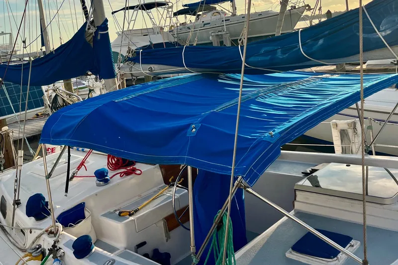 Slide: The Image of 1978 Morgan 415 sailboat with blue canopy docked at marina. - 5