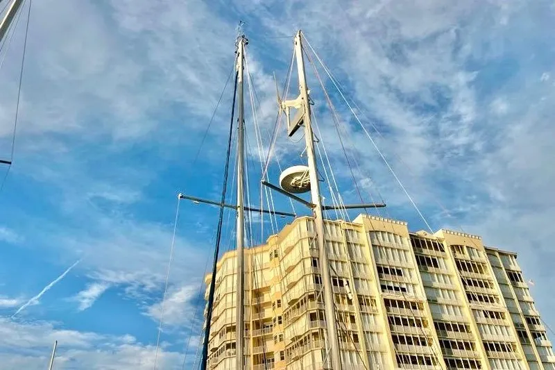 Slide: The Image of Sailboat masts of a 1978 Morgan 415 against a cloudy sky and building backdrop. - 6