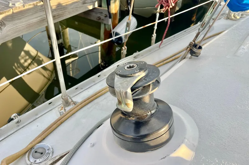 Slide: The Image of 1978 Morgan 415 sailboat deck with winch and ropes near dock. - 8