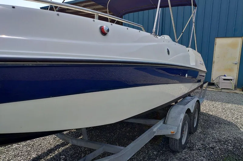 Slide: The Image of 2000 Four Winns Center Console boat on trailer, blue and white hull, parked outdoors. - 2