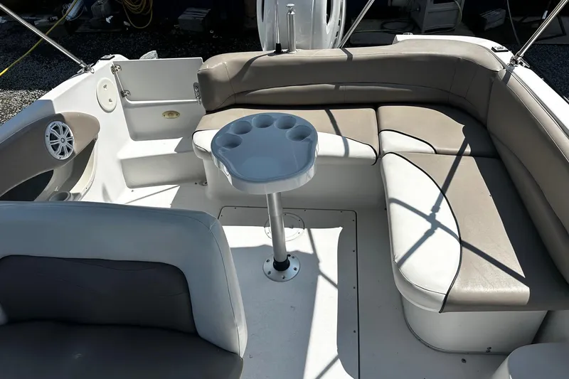 Slide: The Image of 2000 Four Winns Center Console boat interior with seating and cup holder table. - 9