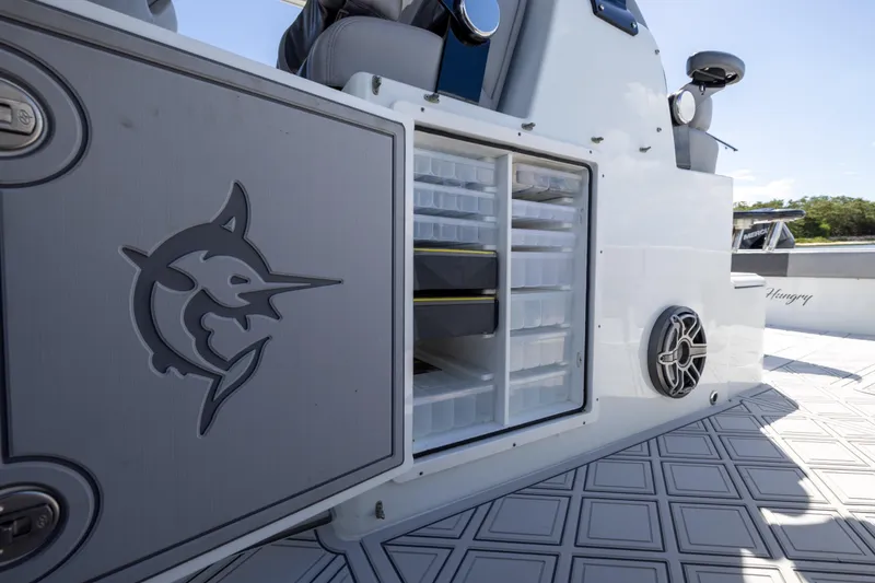 Slide: The Image of 2023 Freeman 47 boat with open storage compartment and marlin logo. - 105