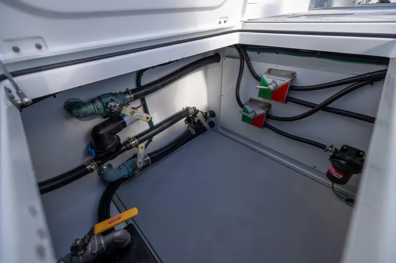 Slide: The Image of Freeman 47 boat plumbing system, 2023 model, featuring pipes and valves in a storage compartment. - 110