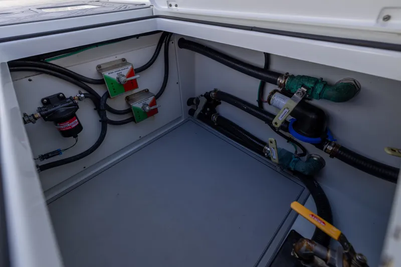 Slide: The Image of 2023 Freeman 47 boat compartment with hoses, valves, and electrical components. - 111