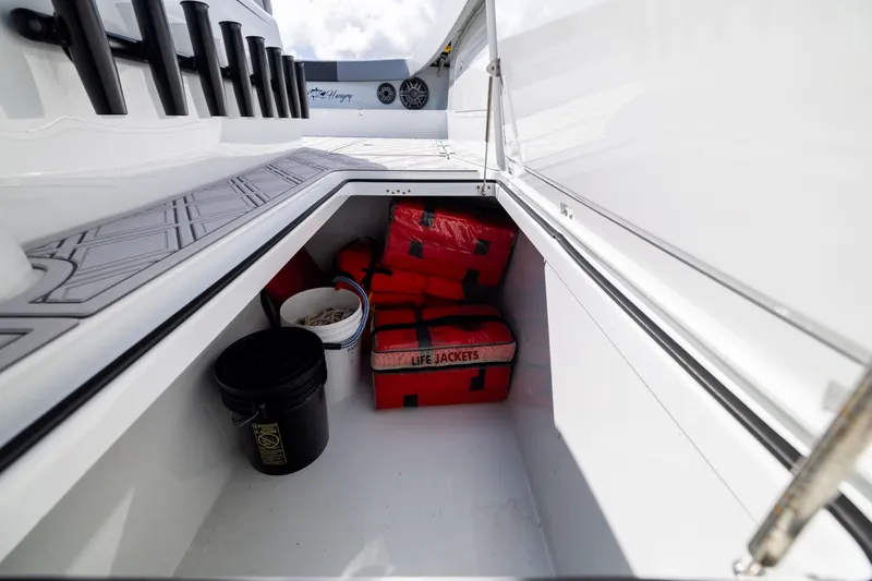 Slide: The Image of Storage compartment on a 2023 Freeman 47 boat with life jackets and buckets. - 115