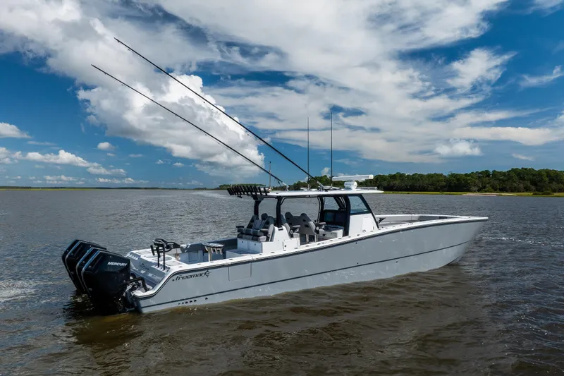 Slide: The Image of 2023 Freeman 47 boat cruising on a calm lake under a blue sky. - 15