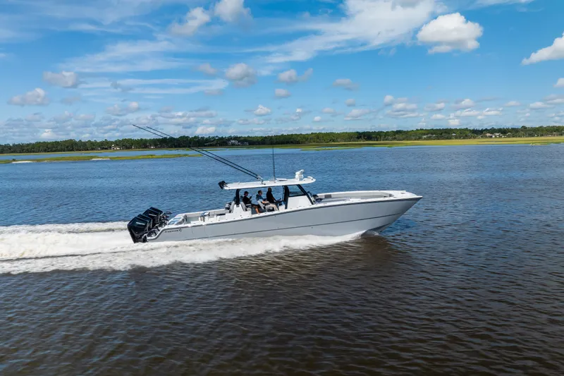 Slide: The Image of 2023 Freeman 47 boat cruising on a calm river under a clear blue sky. - 23