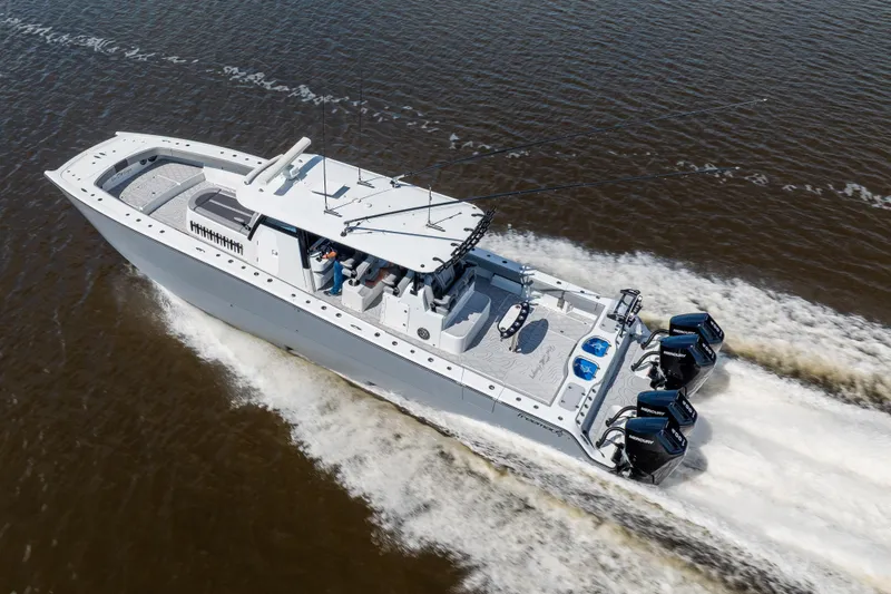 Slide: The Image of 2023 Freeman 47 boat cruising on water, featuring powerful outboard engines. - 28