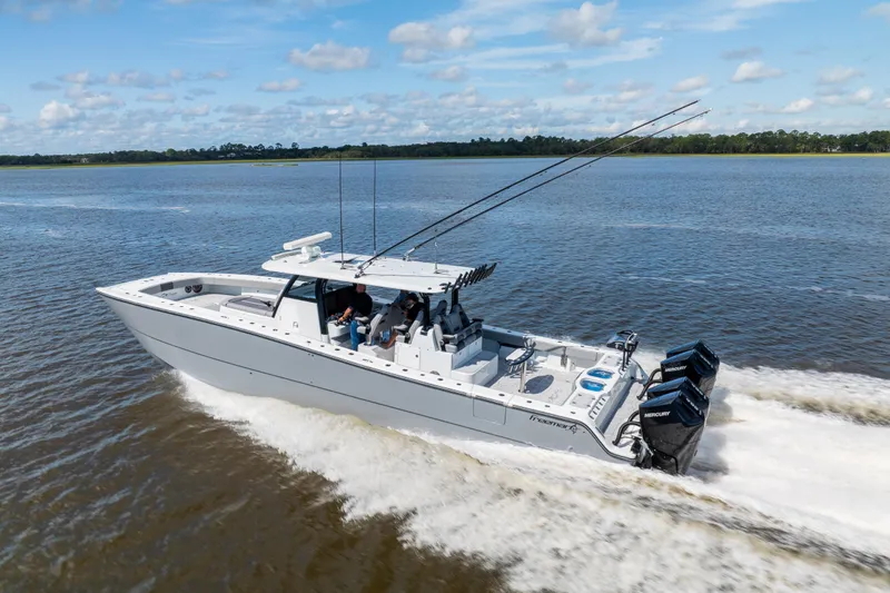 Slide: The Image of 2023 Freeman 47 boat cruising on a calm river under a blue sky. - 30