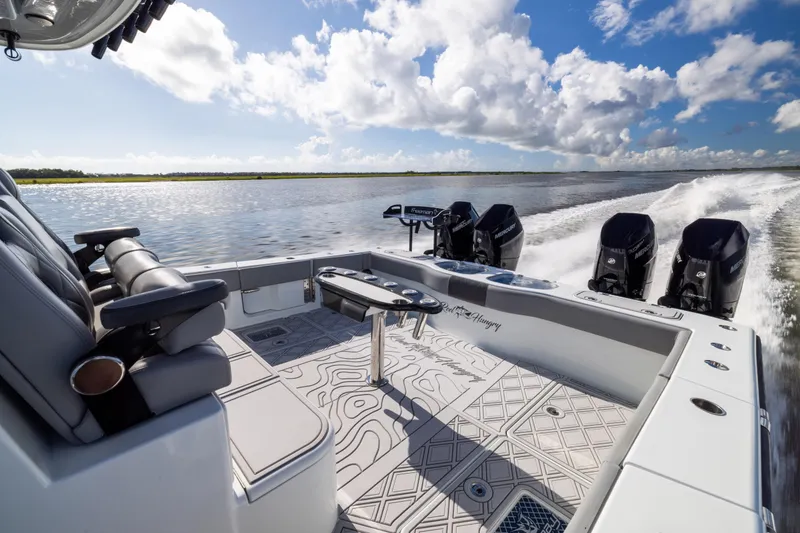 Slide: The Image of 2023 Freeman 47 boat cruising on water, featuring luxurious seating and powerful engines. - 32