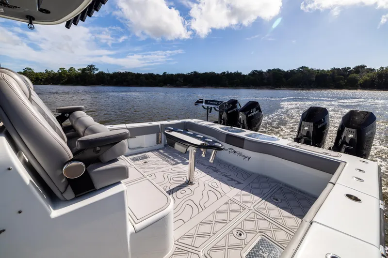 Slide: The Image of 2023 Freeman 47 boat interior with seating and multiple outboard motors on a sunny day. - 38