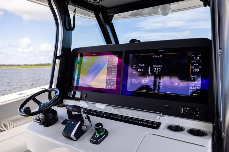 Slide: The Image of 2023 Freeman 47 boat dashboard with dual Simrad displays, steering wheel, and controls. - 69