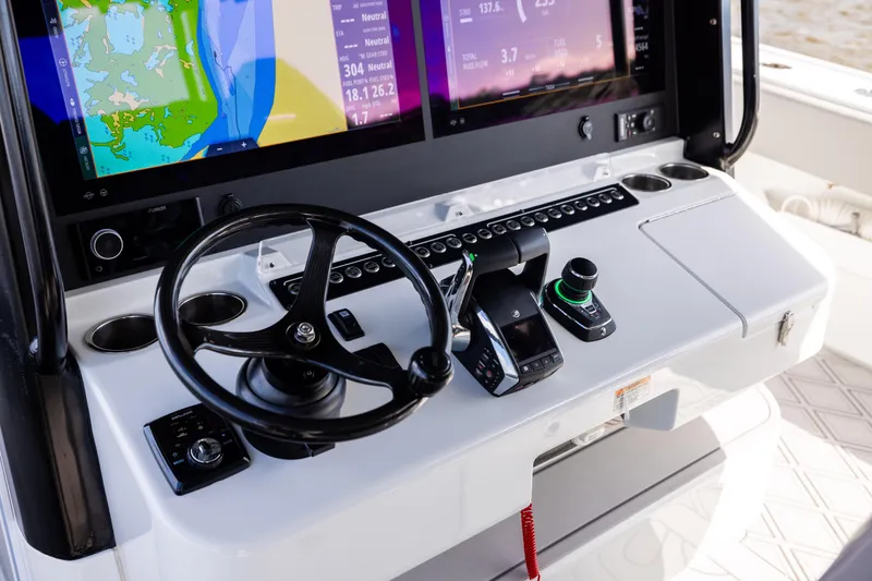 Slide: The Image of Control panel of a 2023 Freeman 47 boat with navigation screens and steering wheel. - 72