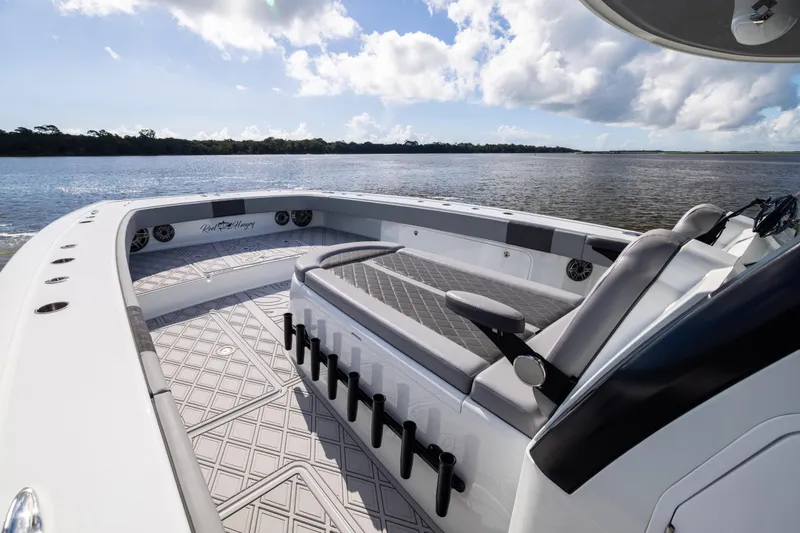 Slide: The Image of 2023 Freeman 47 boat interior with seating, on a calm water body under a blue sky. - 74