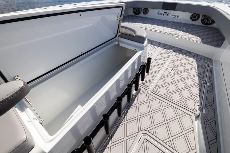 Slide: The Image of 2023 Freeman 47 boat interior with open storage, rod holders, and patterned flooring. - 80