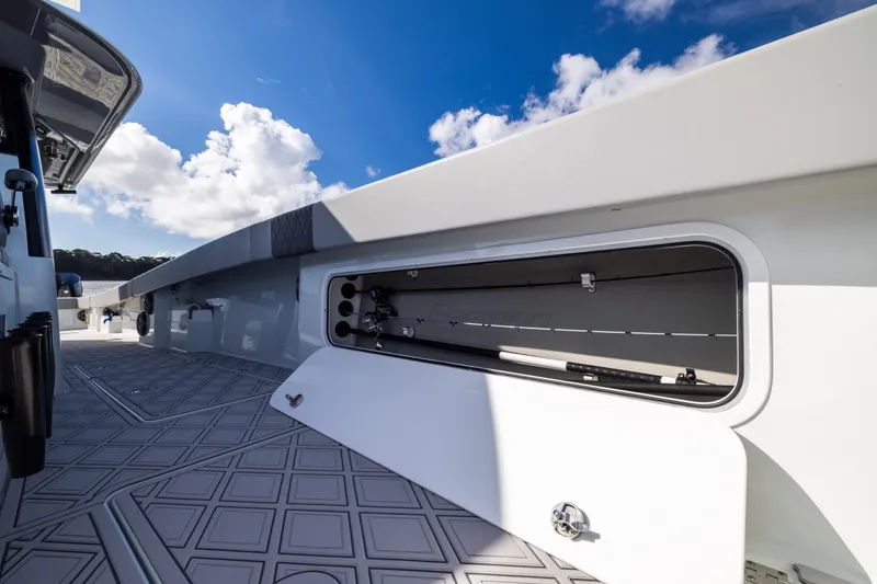 Slide: The Image of 2023 Freeman 47 boat deck with open storage compartment under clear blue sky. - 83